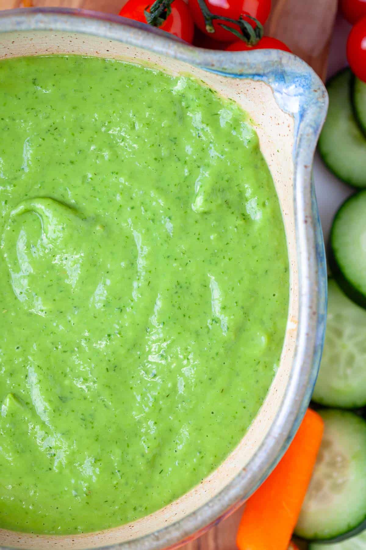 close up image of vibrant Vegan Green Goddess Dressing in serving bowl. 